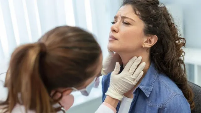 Doctor examining a patient's throat for swallowing difficulty